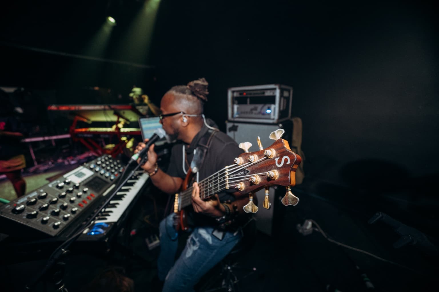 Jermaine Williams seated with bass, keys, and a Moog before a performance